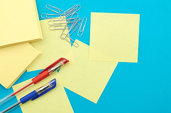 Yellow sticky notes and pens on blue background