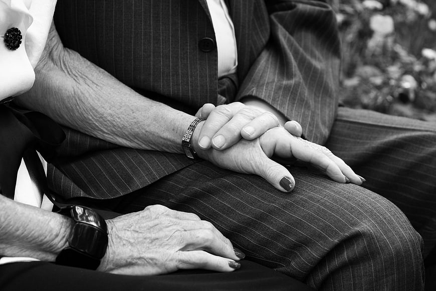 Senior couple holding hands in black and white