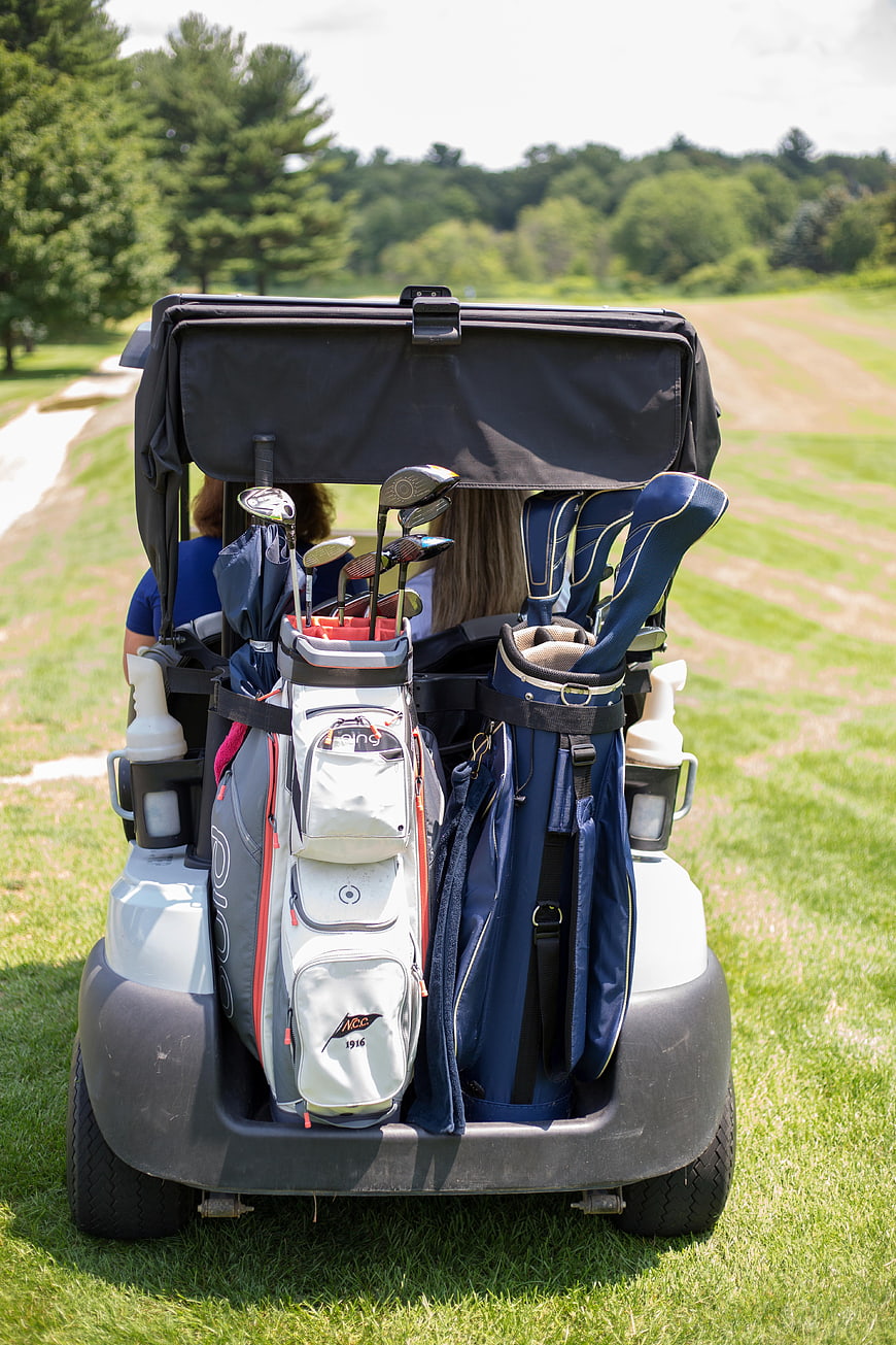 Golf Cart with Bags and Clubs on Green Course
