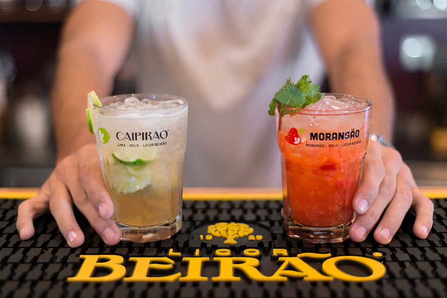 Bartender serving Caipirao and Morango cocktails on bar mat