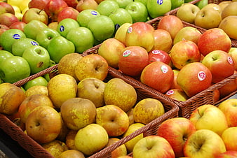 Assorted fresh apples in wicker baskets at a market