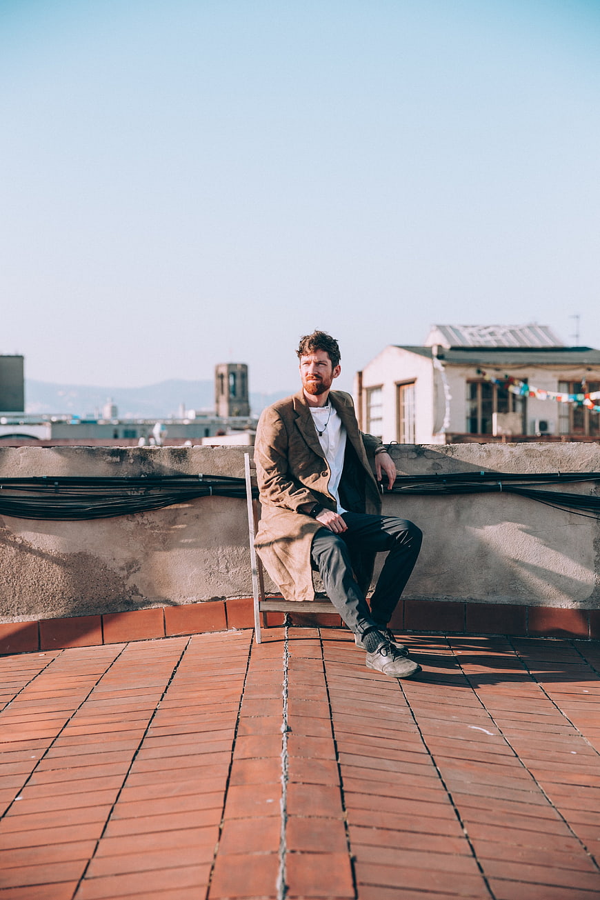 Stylish Man Sitting on Rooftop with City View
