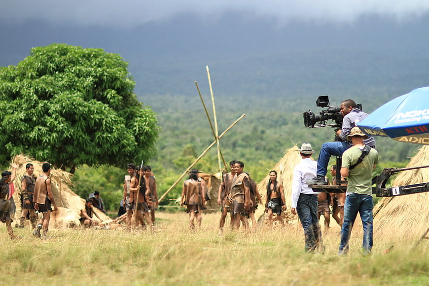Film crew shooting movie scene with tribal actors in village