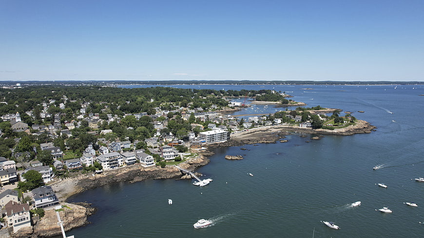 Aerial view of coastal town with boats on blue water