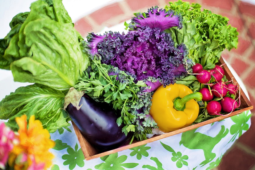 Fresh organic vegetables in a wooden crate on a table