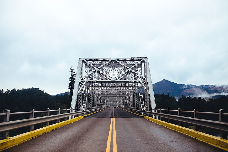 Symmetrical View of Steel Truss Bridge with Mountain Background