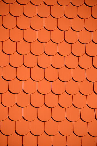 Close-up of orange roof tiles in a repeating fish-scale pattern