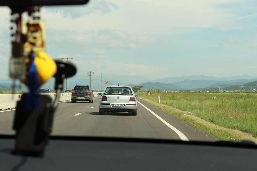 View from car dashboard driving on highway with mountains
