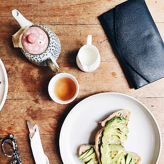 Flat lay of avocado toast breakfast with tea on wooden table