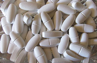 Close-up of white oval calcium and vitamin D supplement tablets