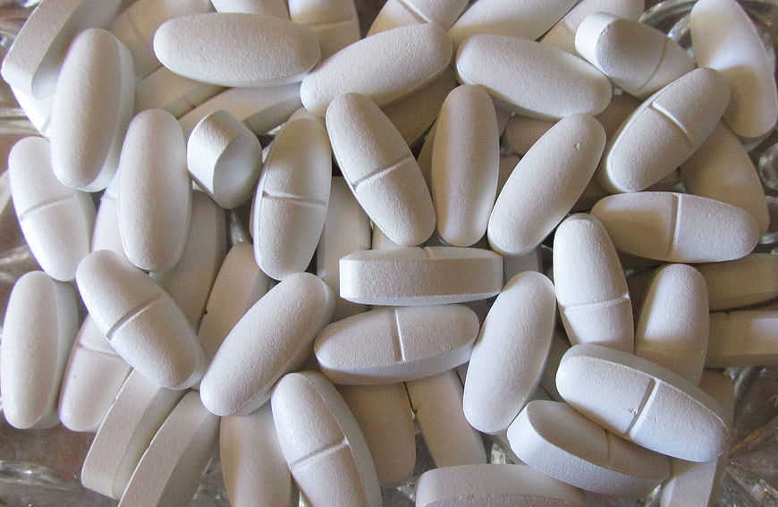 Close-up of white oval calcium and vitamin D supplement tablets