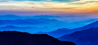 Panoramic Blue Mountain Ranges at Sunrise with Misty Layers