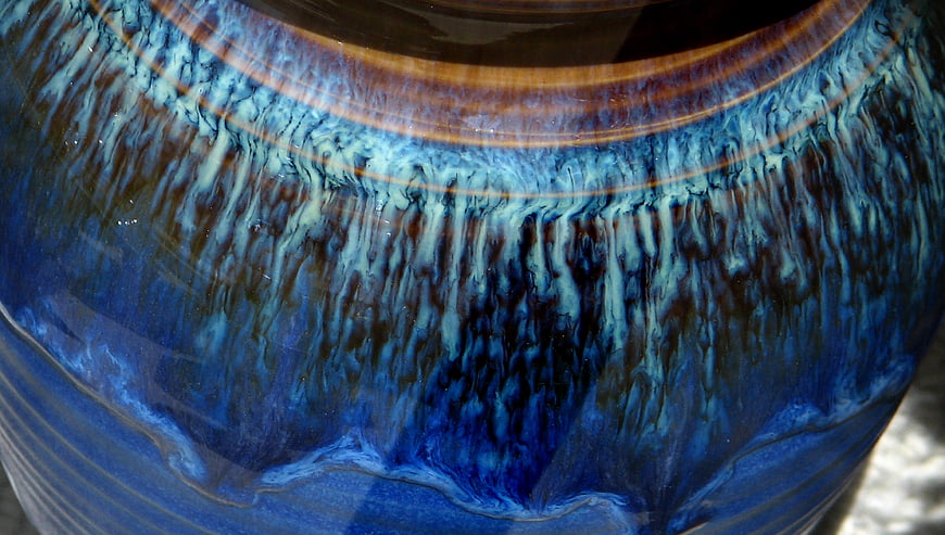 Close-up of blue ceramic pottery with dripping glaze texture