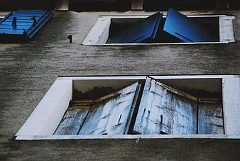 Weathered blue wooden shutters on a textured concrete wall