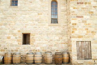 Wooden Wine Barrels Against Rustic Stone Wall