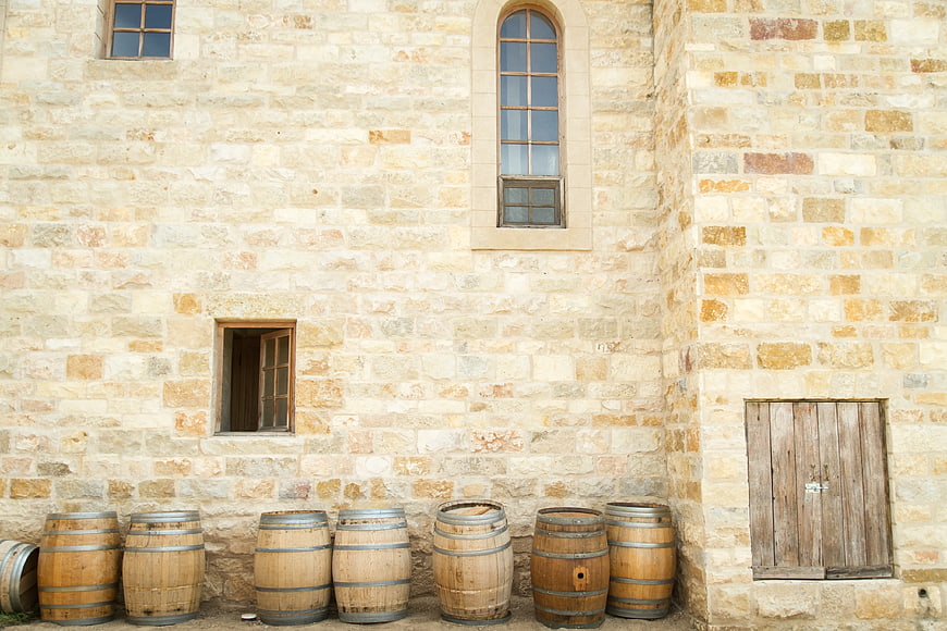 Wooden Wine Barrels Against Rustic Stone Wall