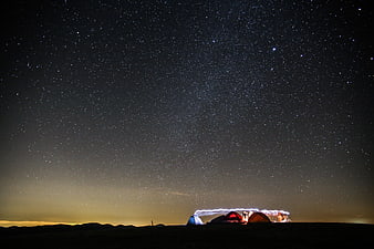 Camping Tents Under Starry Night Sky with Light Trails