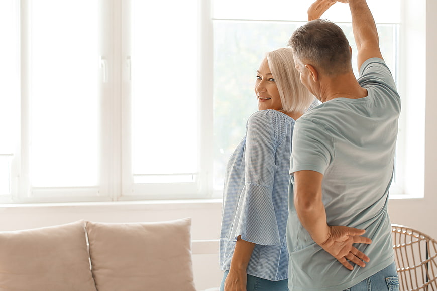 Happy Senior Couple Dancing Together in Bright Living Room