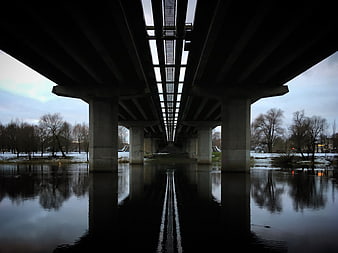 Symmetrical View Under Concrete Highway Bridge Over River