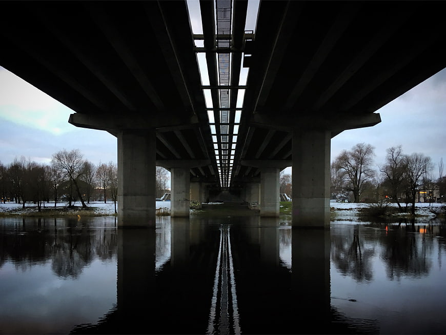 Symmetrical View Under Concrete Highway Bridge Over River