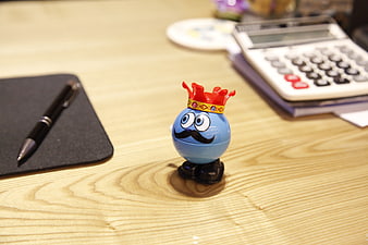 Blue King Toy Figurine on Wooden Office Desk