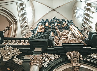 Baroque church organ with ornate sculptures and vaulted ceiling