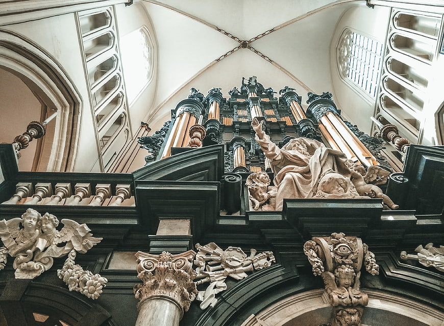 Baroque church organ with ornate sculptures and vaulted ceiling