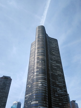 Low angle view of modern glass skyscraper against blue sky
