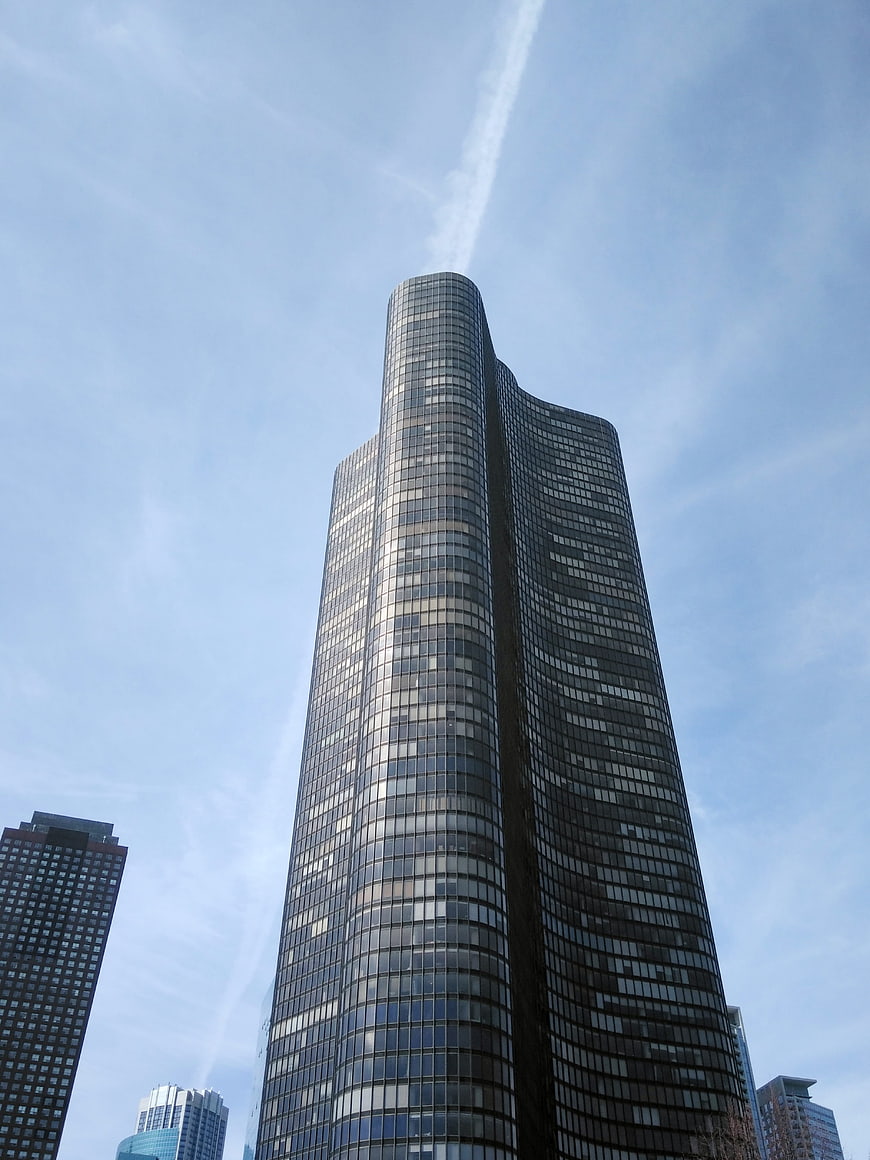 Low angle view of modern glass skyscraper against blue sky
