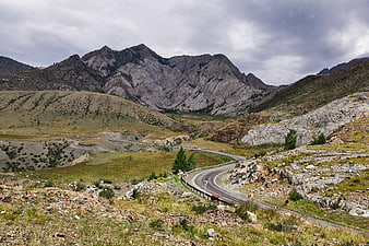 Winding mountain road through rugged alpine landscape