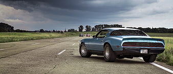 Rear View Of Classic Blue Ford Mustang On Rural Road