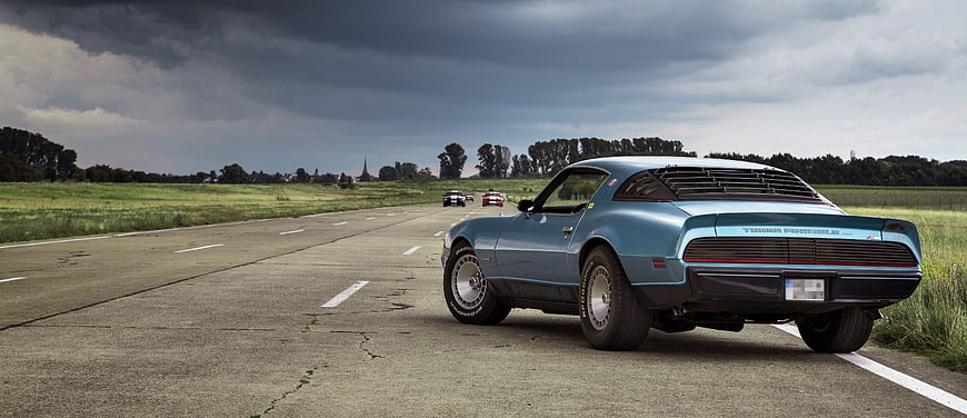Rear View Of Classic Blue Ford Mustang On Rural Road