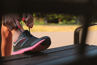 Woman Tying Black and Pink Running Shoe Laces