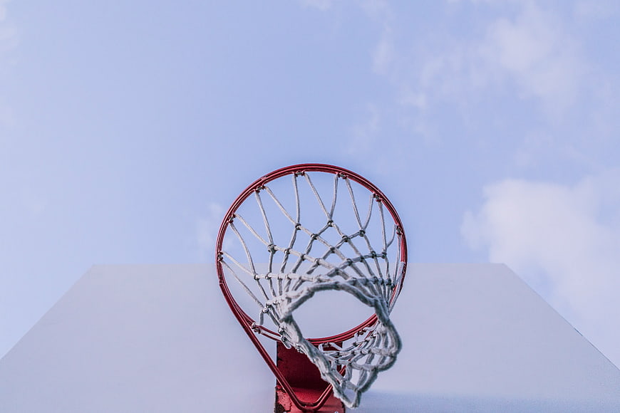 Red Basketball Hoop and Net Against Blue Sky