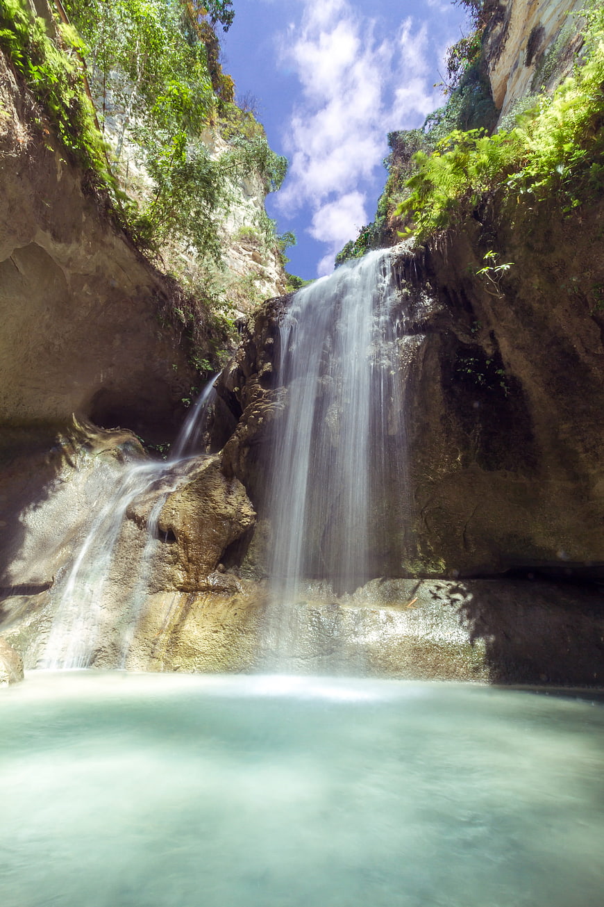 Serene Waterfall Cascading into Turquoise Pool in Lush Canyon