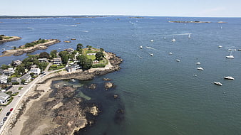 Aerial View of Coastal Town with Boats in Blue Ocean