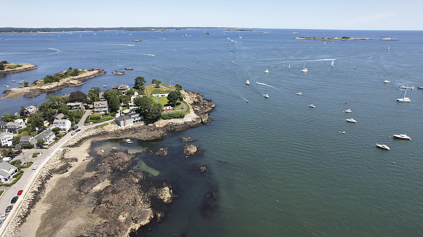 Aerial View of Coastal Town with Boats in Blue Ocean