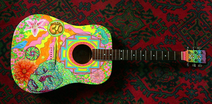 Colorful Psychedelic Painted Acoustic Guitar on Patterned Rug