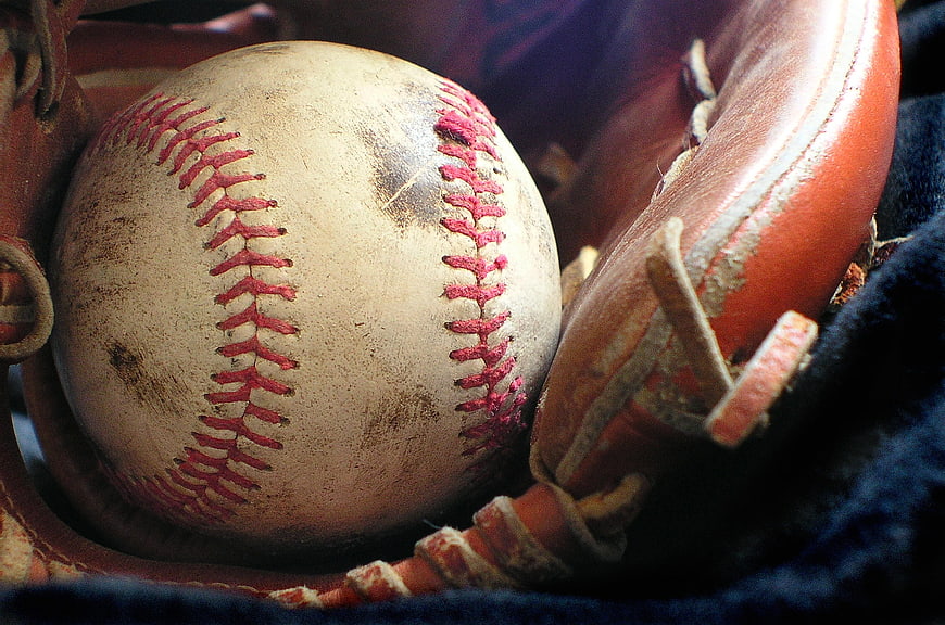 Vintage Baseball in Worn Leather Glove Close Up
