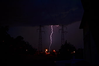 Dramatic Lightning Strike Between Power Lines at Night