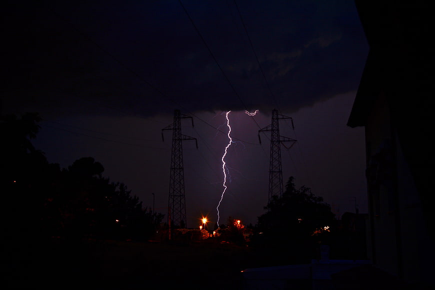 Dramatic Lightning Strike Between Power Lines at Night