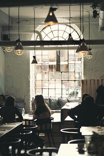 Industrial style cafe interior with large window and patrons