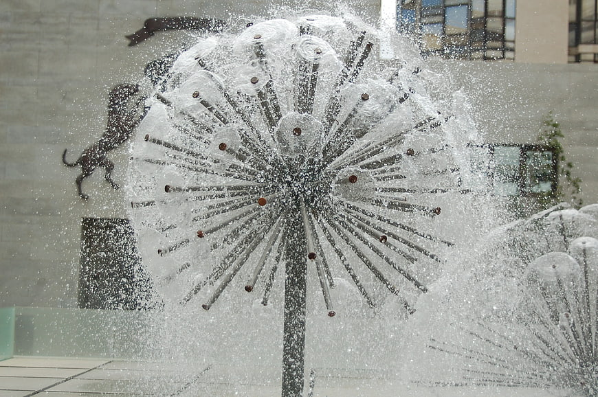 Modern dandelion water fountain sculpture spraying jets