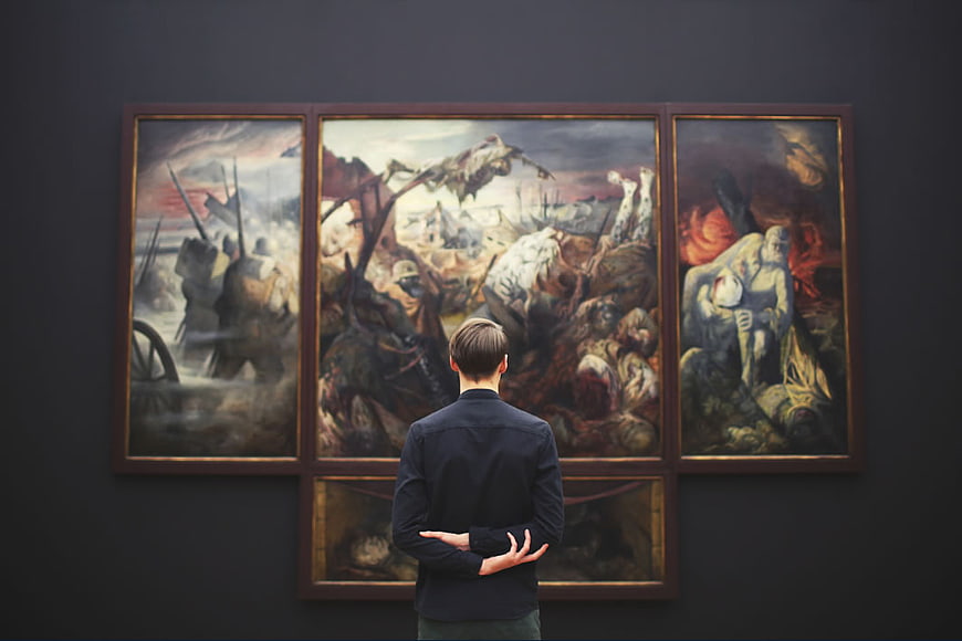 Man Viewing War Triptych in Art Gallery