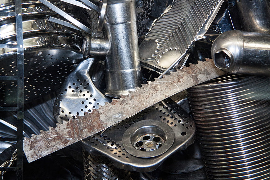 Close-up of stacked stainless steel kitchenware and saw blade