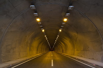 Empty illuminated highway tunnel with perspective leading lines
