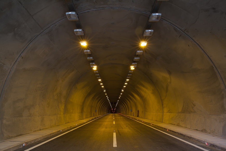 Empty illuminated highway tunnel with perspective leading lines