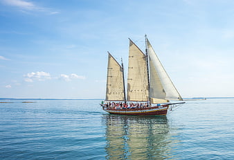Traditional sailing ship with passengers on calm blue sea