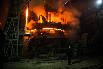 Industrial Worker Walking Near Glowing Molten Steel Blast Furnace