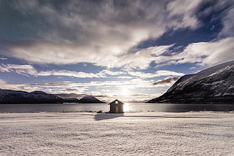 Lone Cabin in Snowy Winter Landscape Under Starry Sky